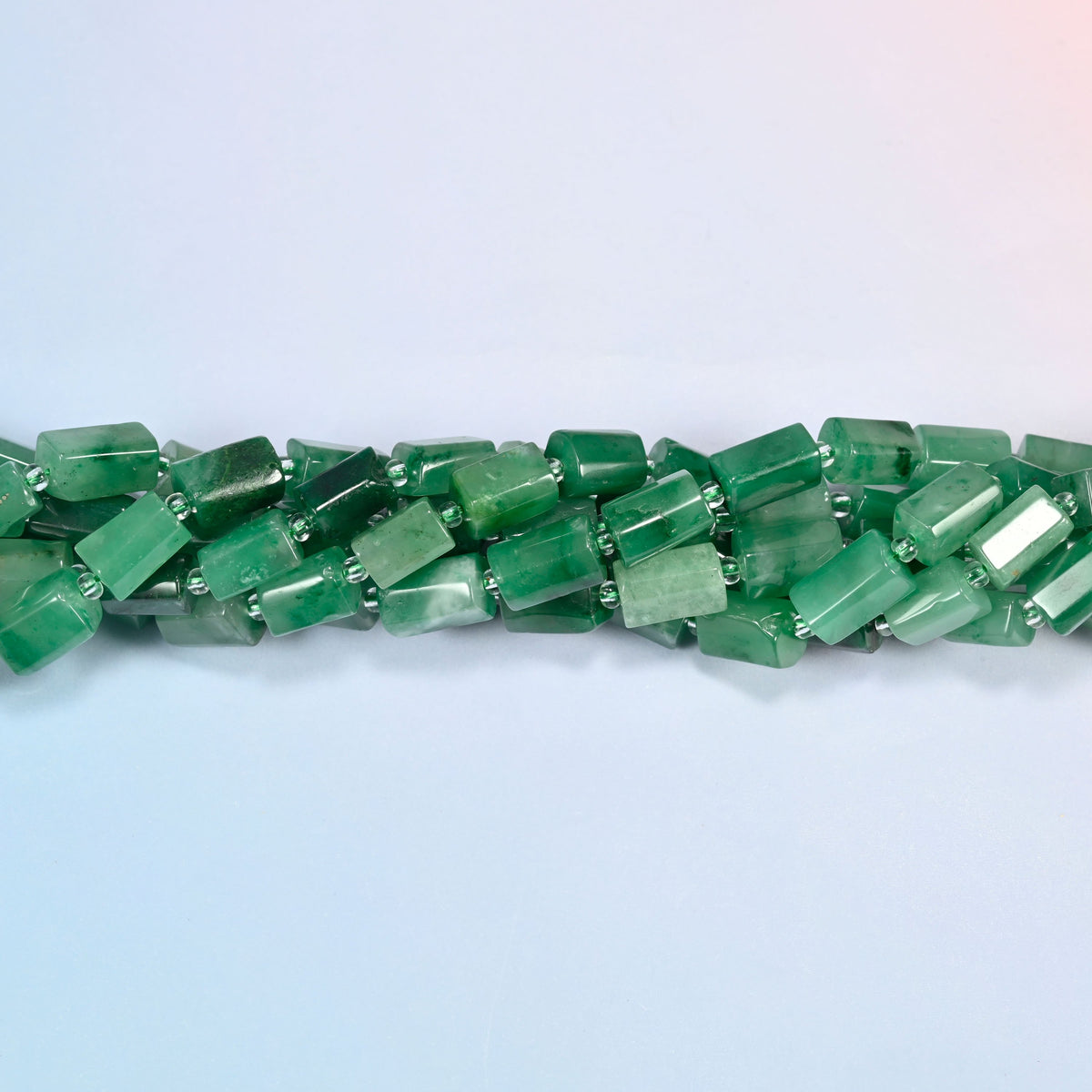 Strands of African jade faceted tube beads twisted together in a horizontal row