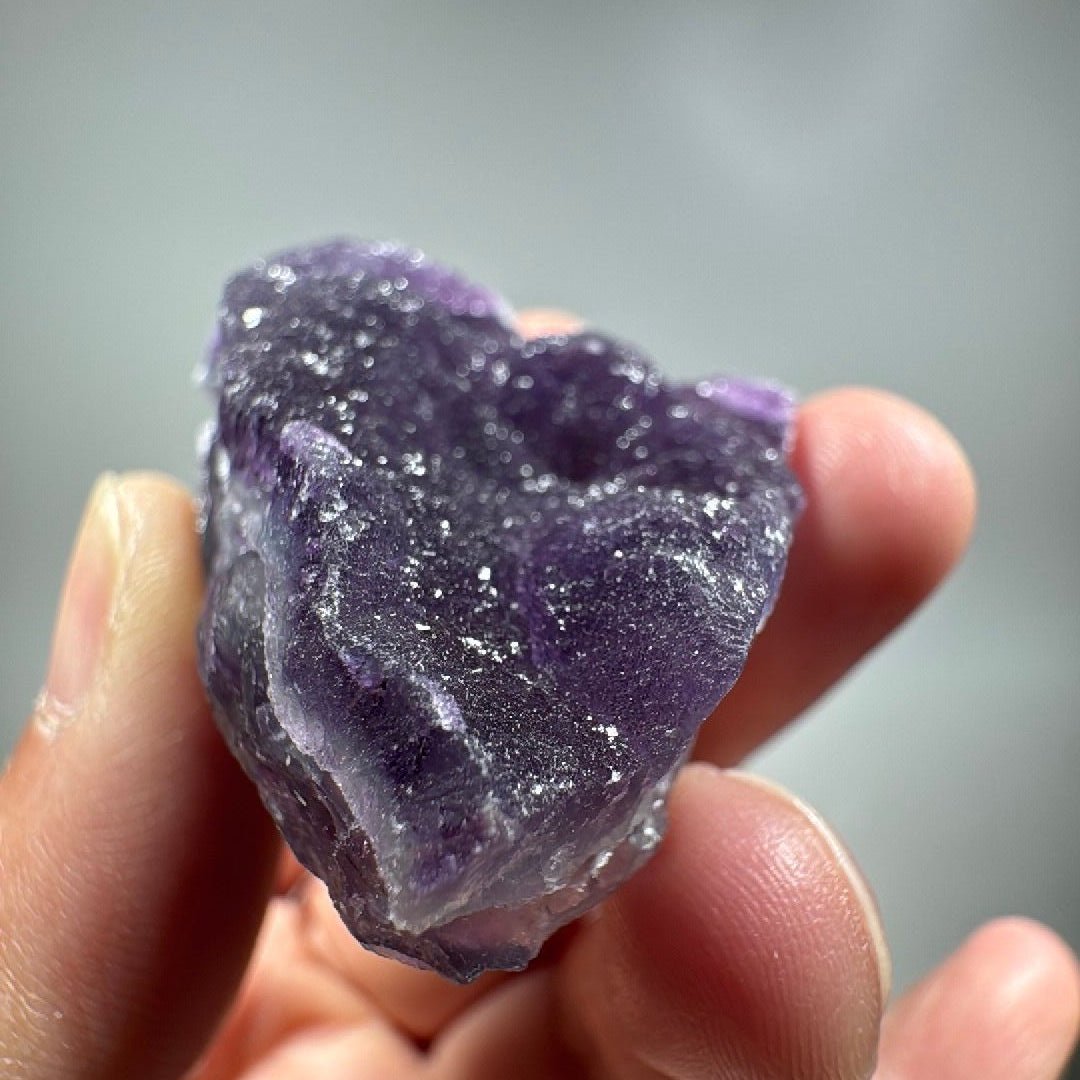 Front face of the specimen, pale lilac crust over darker purple underneath