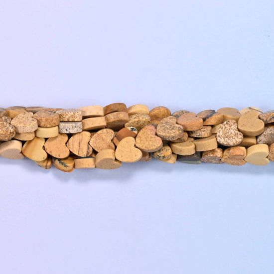 Matte picture jasper flat heart beads in sandy camel and cream with darker brown landscape markings across some faces.