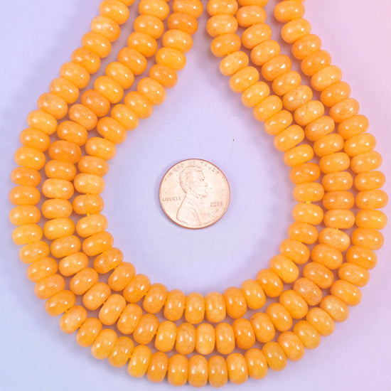 Orange Dyed Jade smooth rondelle beads in a warm golden-orange hue, finished with a smooth, polished surface
