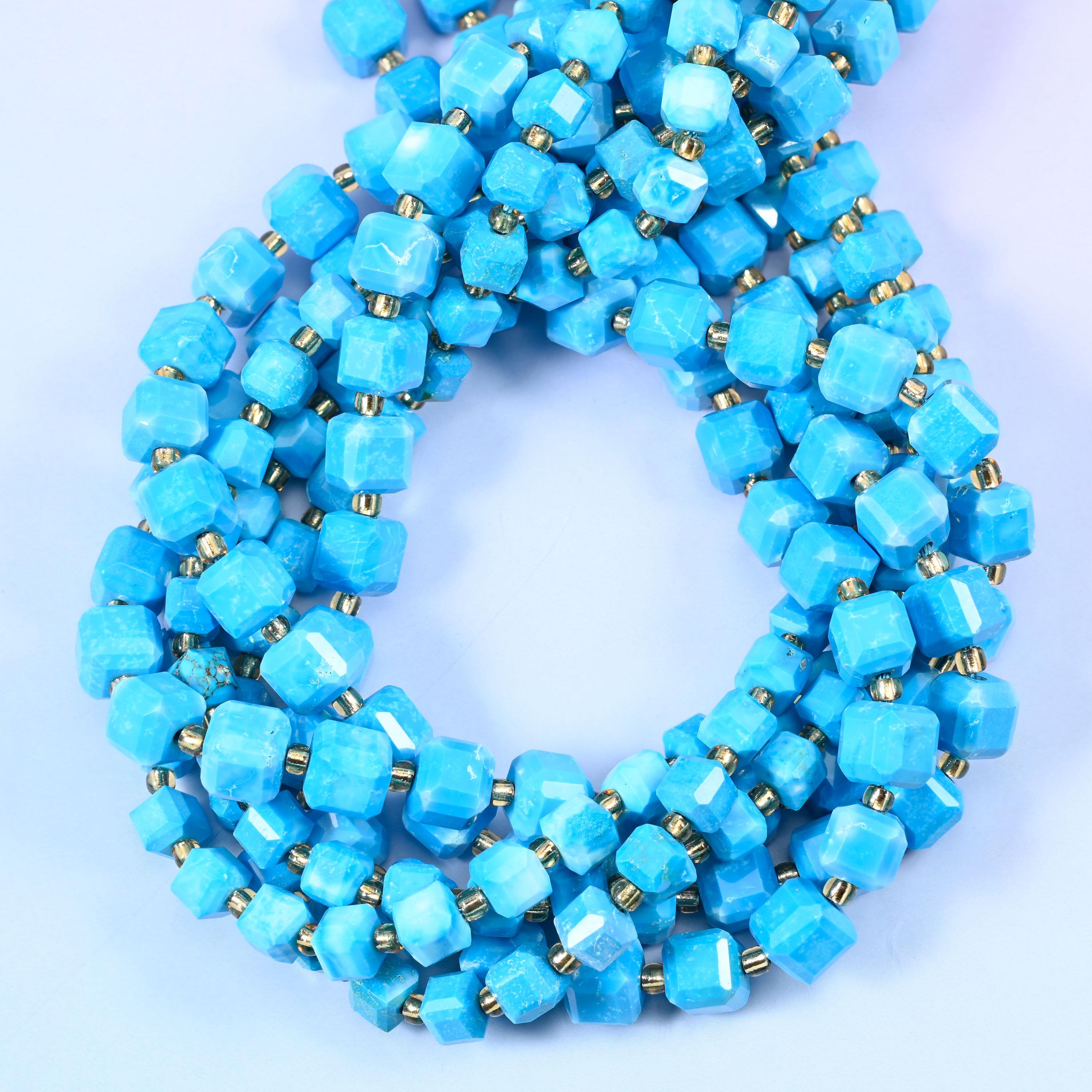 Bright turquoise-blue cubes streaked with paler white veining, faceted at the corners so the flat faces catch the light in small squares.