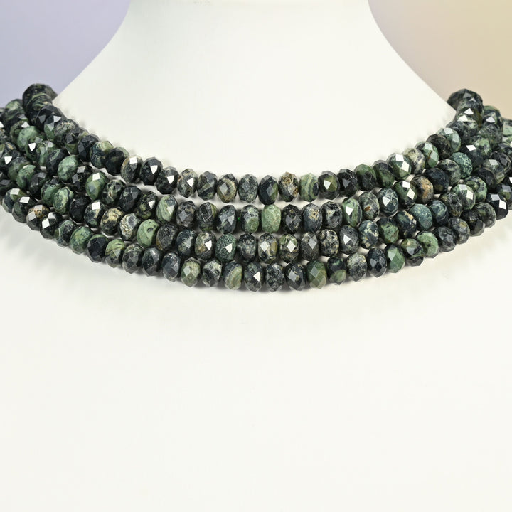 Kambaba jasper faceted rondelle strands arranged as a layered collar on a white display bust, dark green patterned beads across the neck