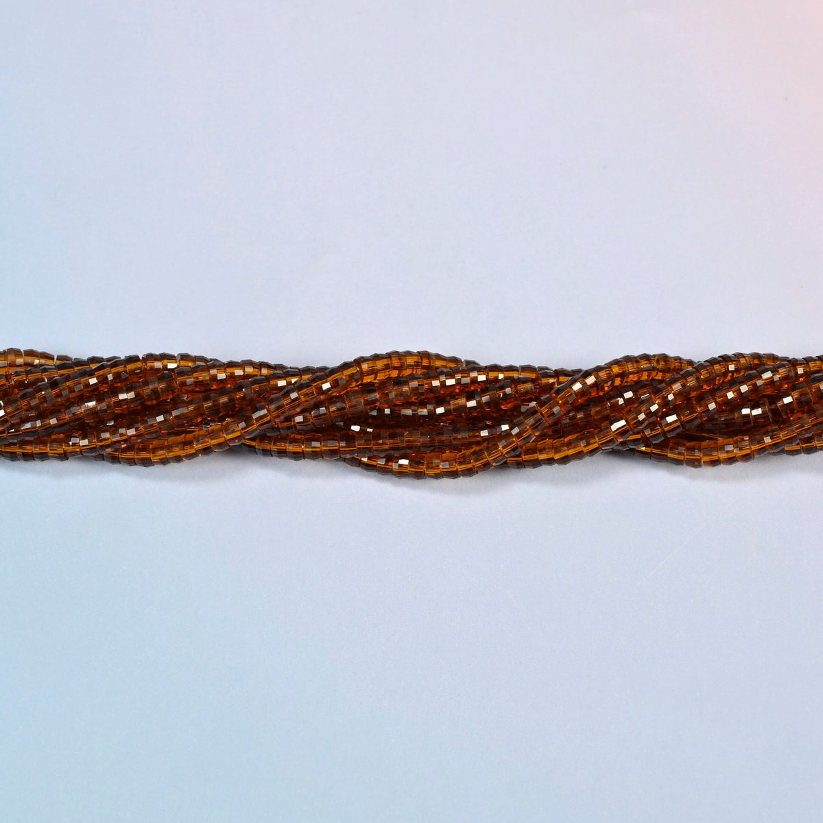 Strands of brown glass faceted heishi disc beads twisted together in a horizontal row