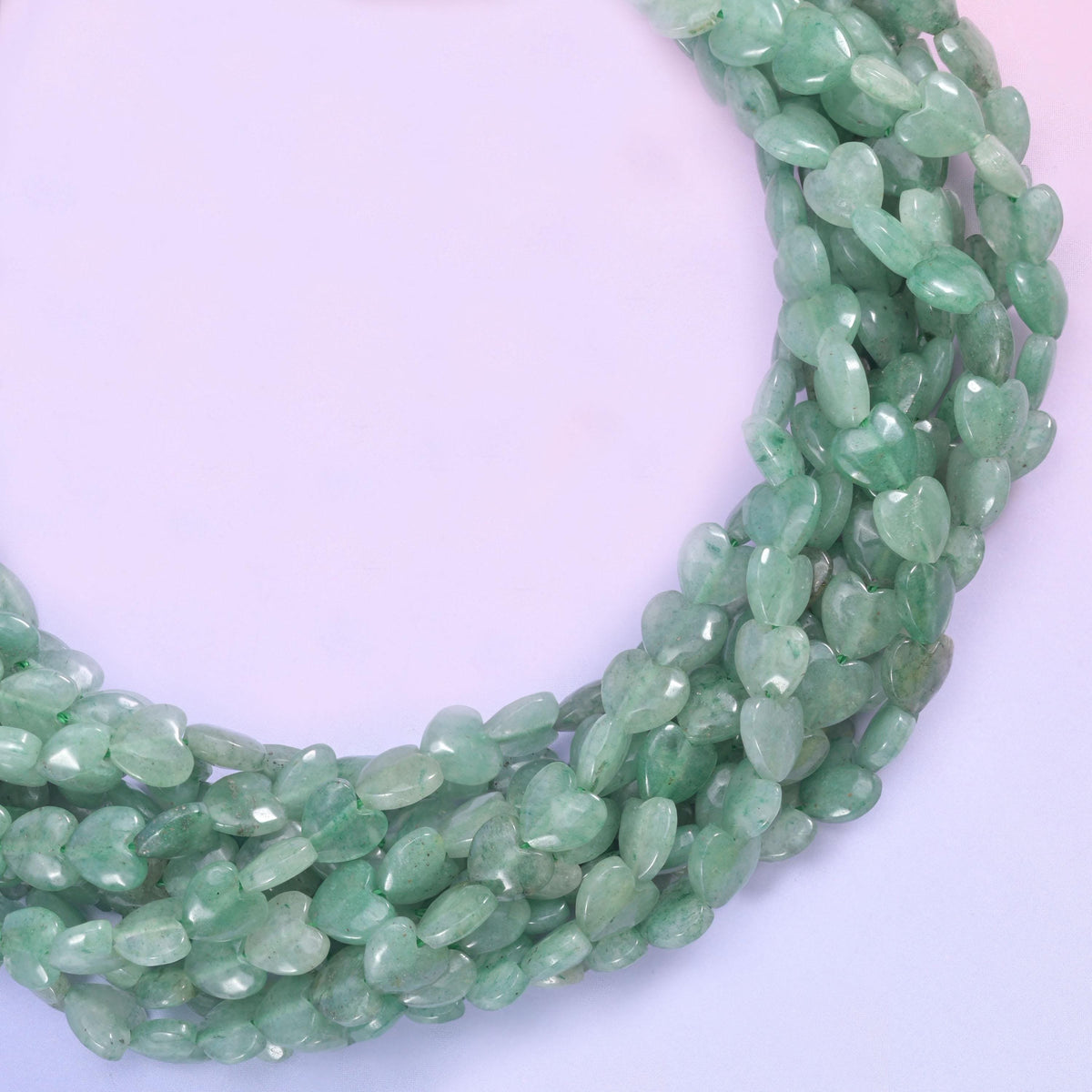 Small puffed hearts in soft sage to deeper moss green, lightly translucent with darker mottling and glittering flecks