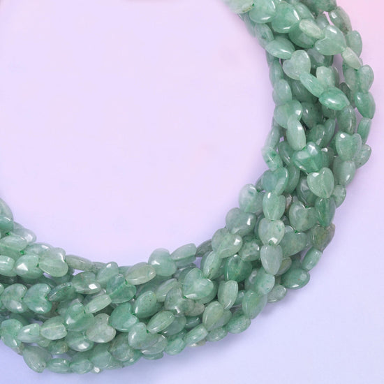 Small puffed hearts in soft sage to deeper moss green, lightly translucent with darker mottling and glittering flecks