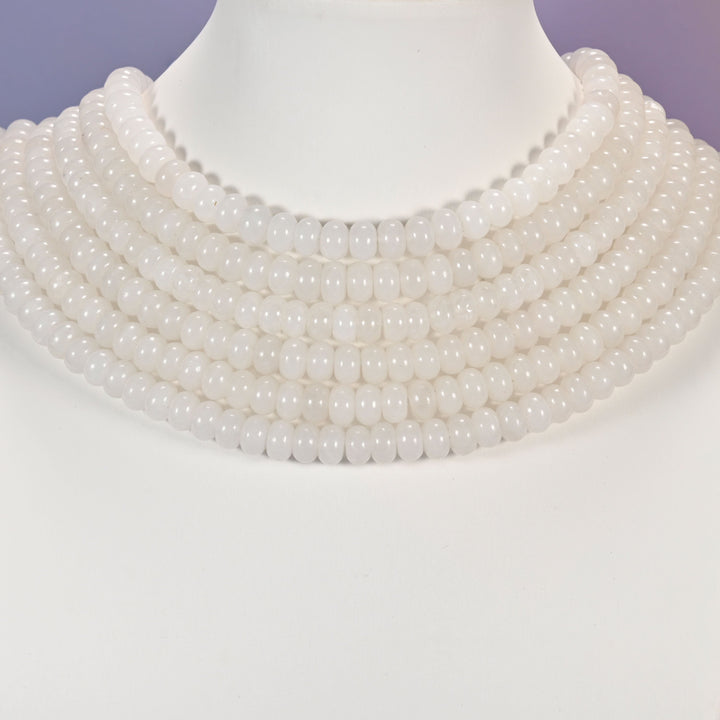 Multi-strand White Jade necklace laid flat on a mannequin neck form against a lavender background.
