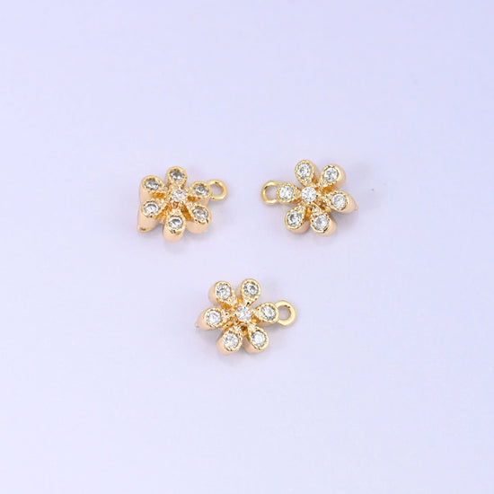 Small gold charms, three flower charms shown close up with the top ring visible