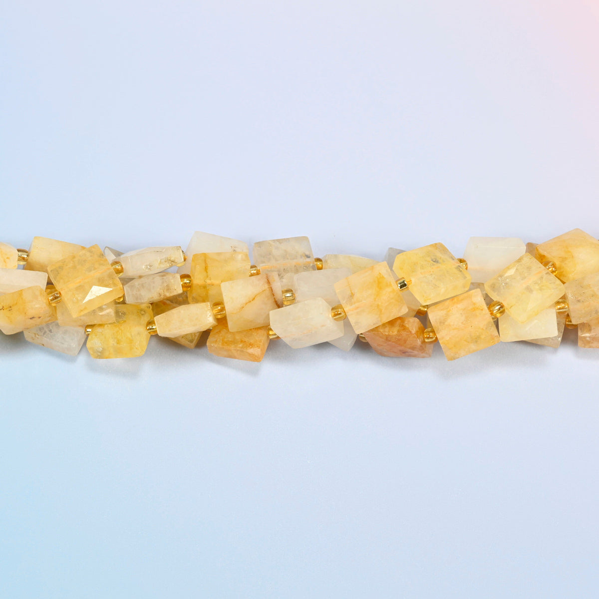 Strands of natural golden healer quartz faceted flat square beads twisted together in a horizontal row