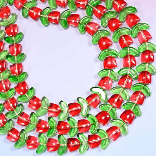 Close-up of a circular coil of red tulip and green leaf glass beads, showing the dense flower and leaf pattern.