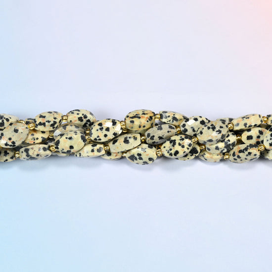 Strands of dalmatian jasper faceted flat oval beads twisted together in a horizontal row