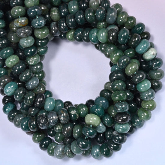 Close-up horizontal row of Moss Agate beads showing the green stone pattern in a tightly coiled strand.
