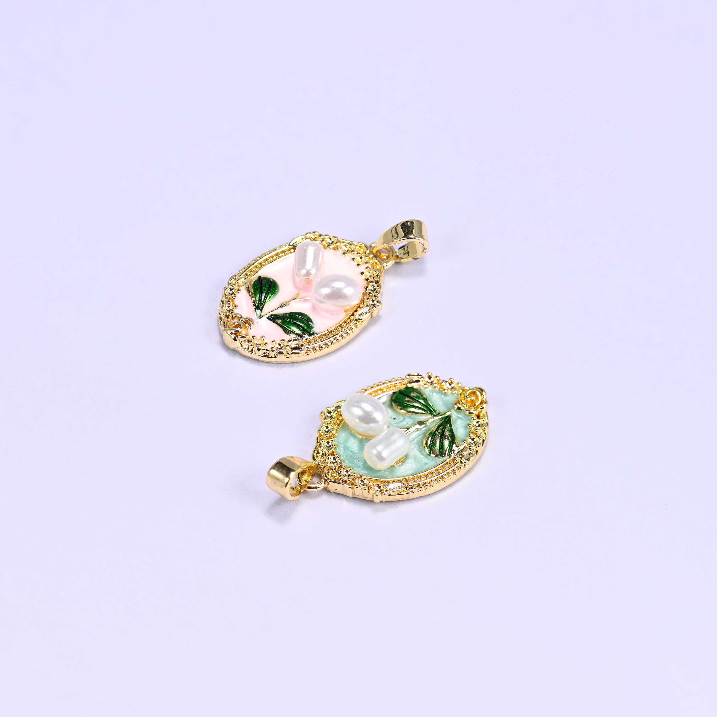 Enamel Oval Tulip Flower Pendants lying at angles on a soft lilac background, the peach oval above and the mint oval below.