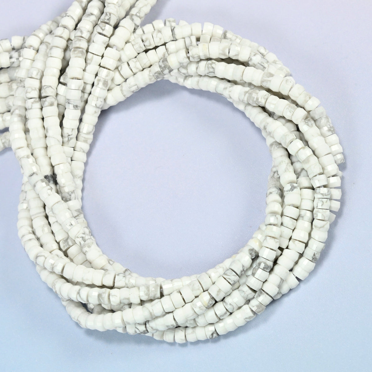 White howlite faceted heishi disc beads coiled into overlapping loops, whole strands of white stone
