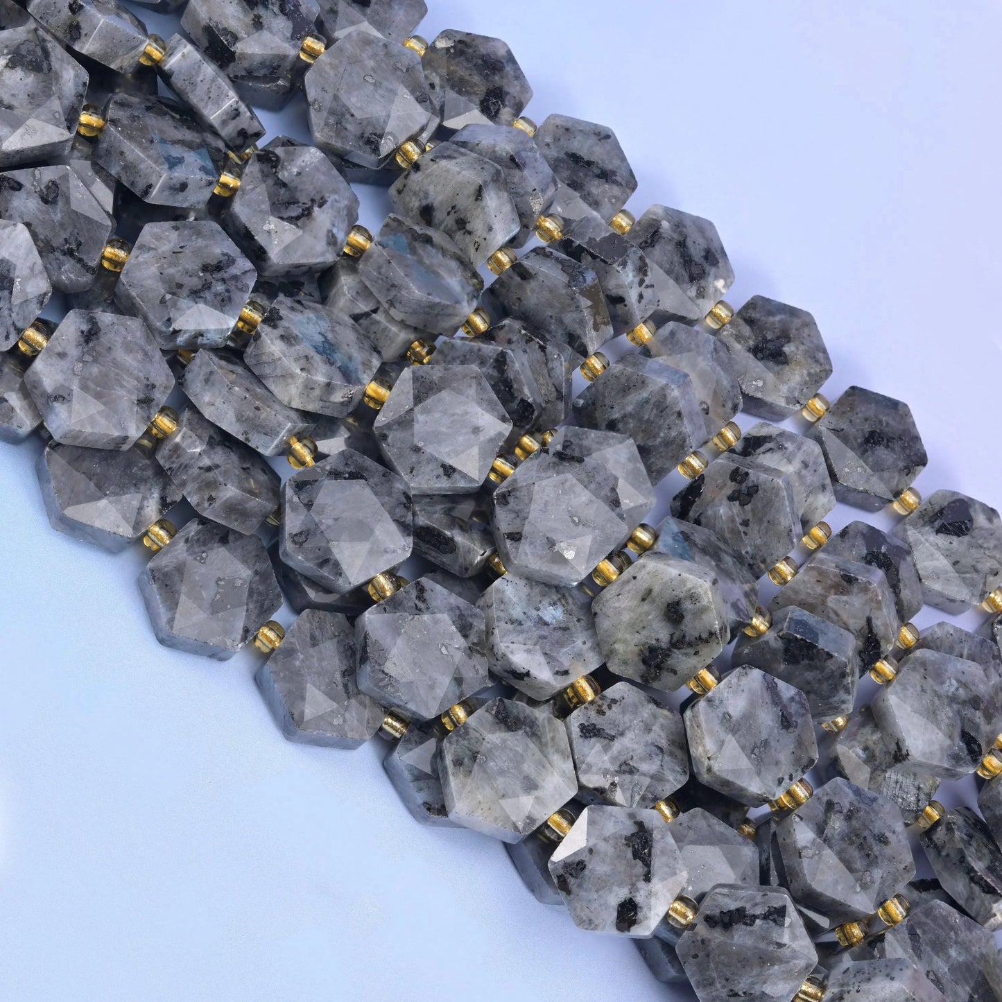Several strands of faceted Labradorite hexagons running diagonally across the frame