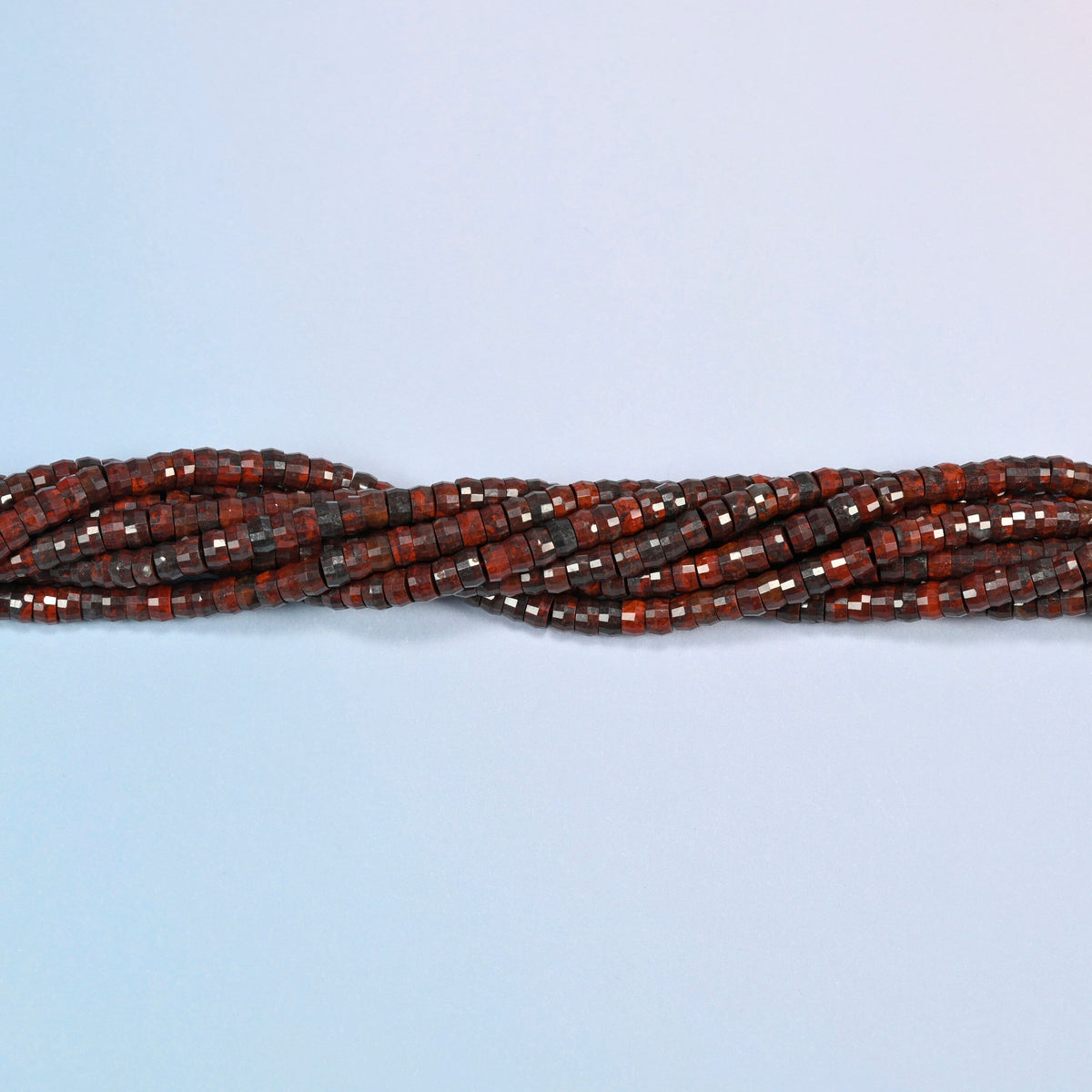 Strands of Zhanguo red agate faceted heishi disc beads twisted together in a horizontal row