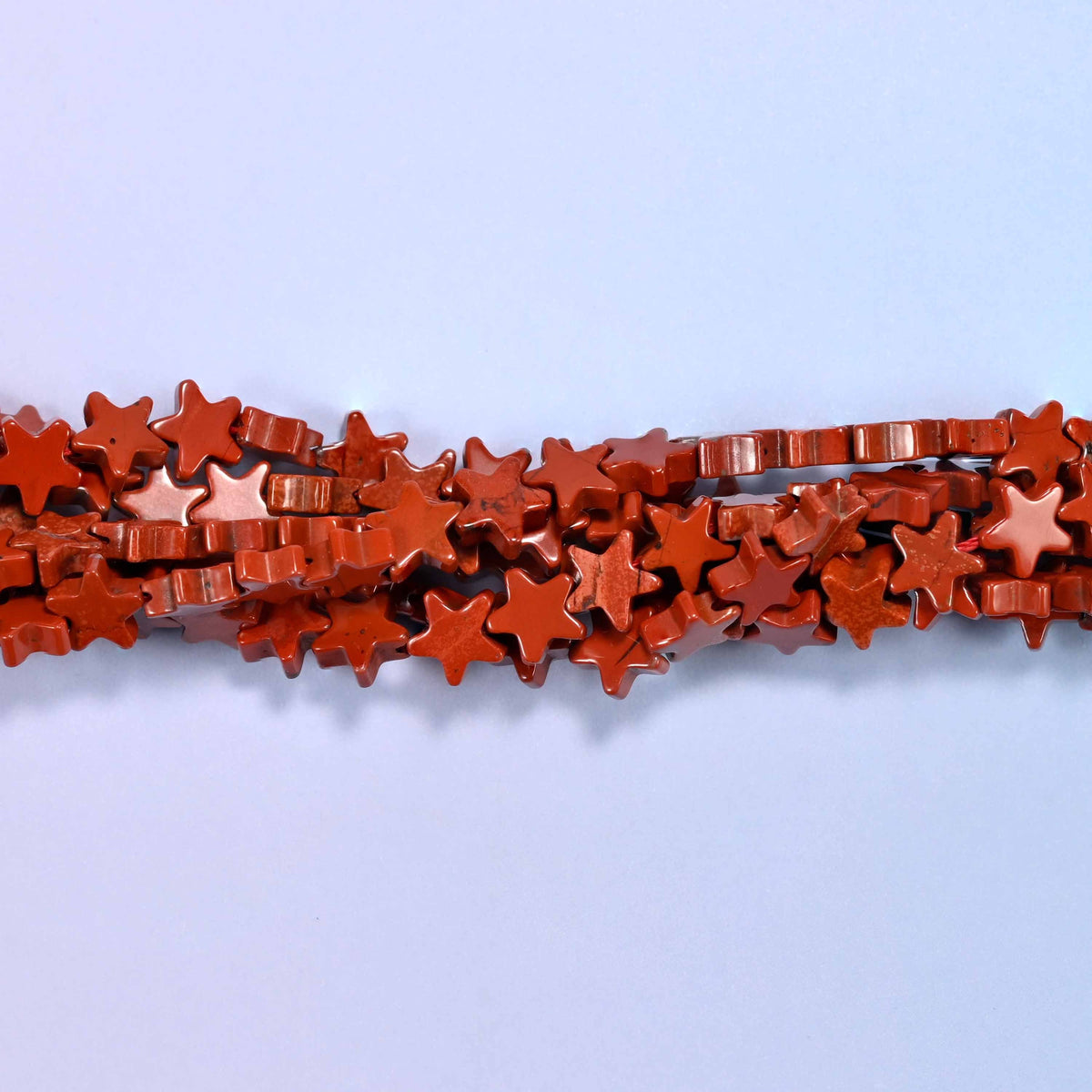 Red jasper flat star beads, approximately 75 per strand