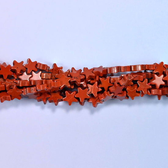 Red jasper flat star beads, approximately 75 per strand