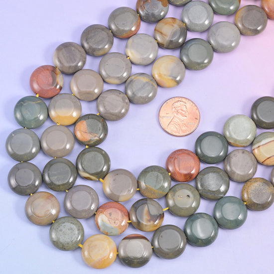 Picture jasper strands looped around a US penny for scale against the 15mm coin beads