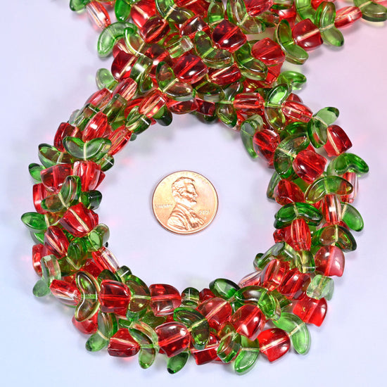 Bundled circular coil of tulip and leaf glass bead strands on a lavender background with a penny placed at the center for scale.