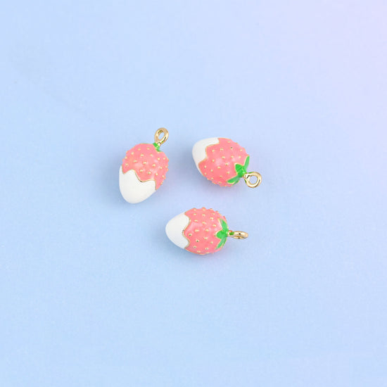 Three strawberry charms dipped in white enamel, red berry above with white seed dots.