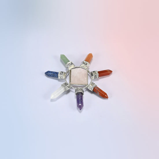 Crystal energy generator with a pink rose quartz center pyramid and seven chakra crystal points in a silver-tone frame