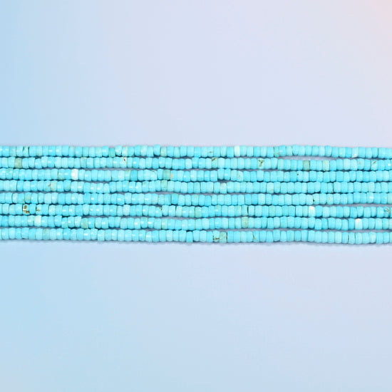 Several strands of dyed blue howlite faceted heishi disc beads laid in straight rows