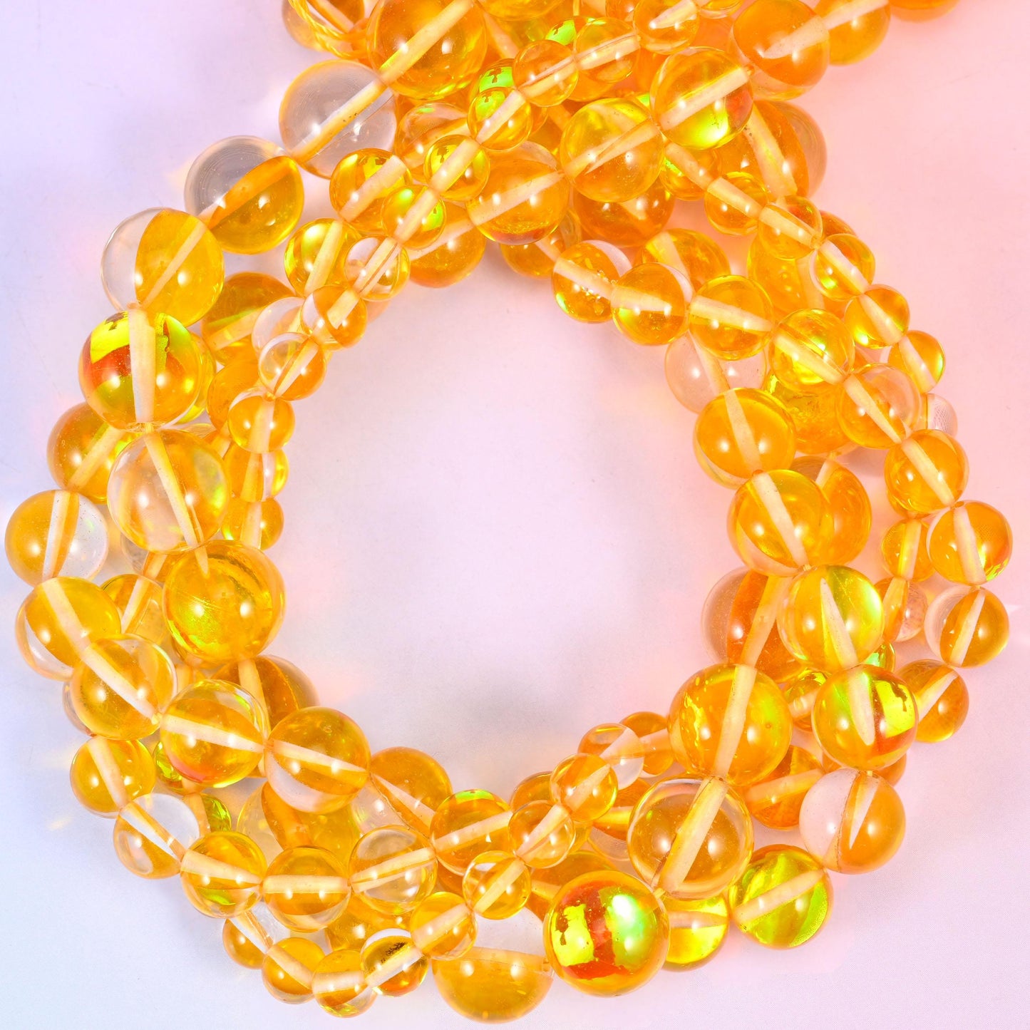 Clear golden-amber rounds finished with an iridescent aura coating that flashes green, pink and gold