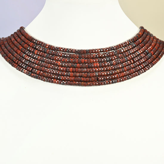 Zhanguo red agate faceted heishi disc strands arranged as a layered collar on a white display bust, red-brown beads across the neck