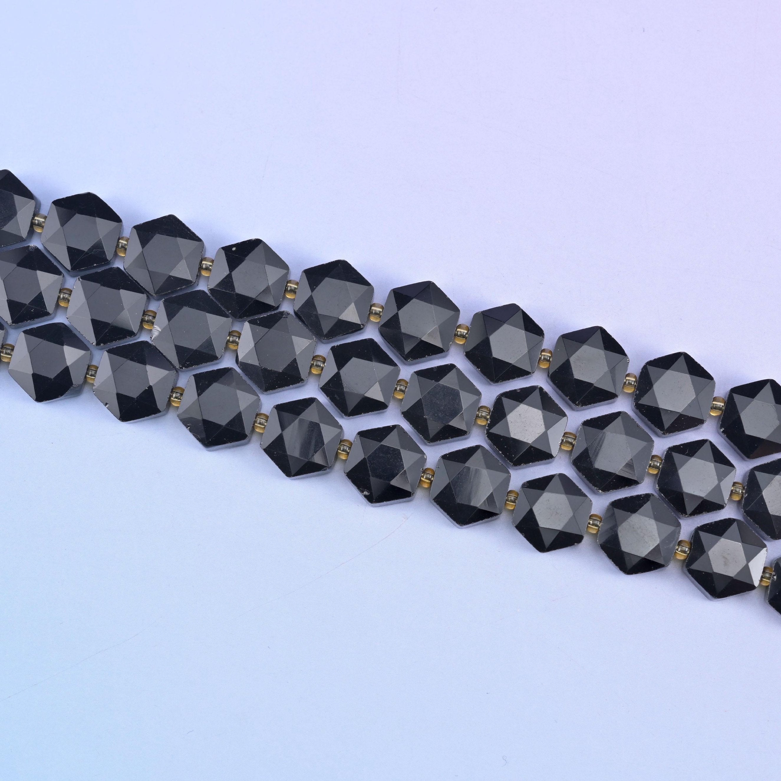 Two strands of 12mm obsidian hexagons stretched diagonally, flat discs lying in an even row