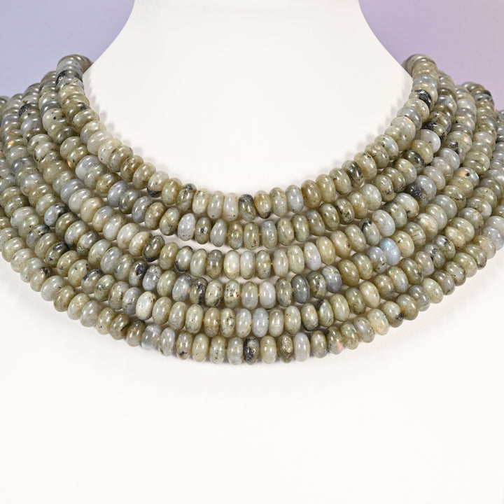 Multi-strand Grey Labradorite necklace laid flat on a mannequin neck form against a lavender background.