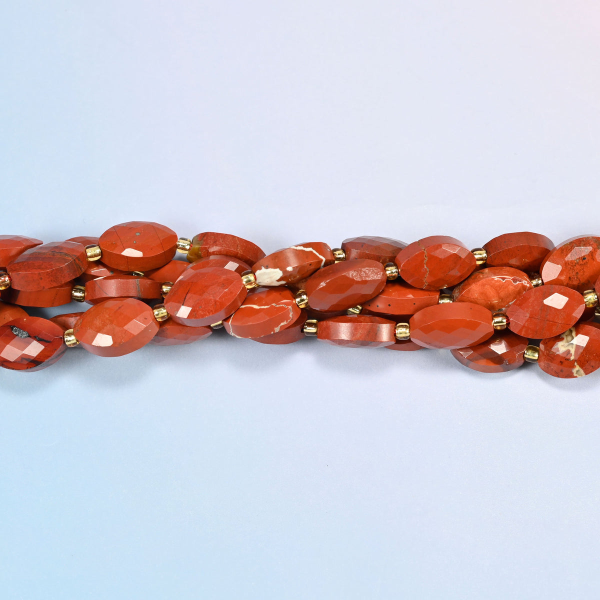 Strands of flower red jasper faceted flat oval beads twisted together in a horizontal row