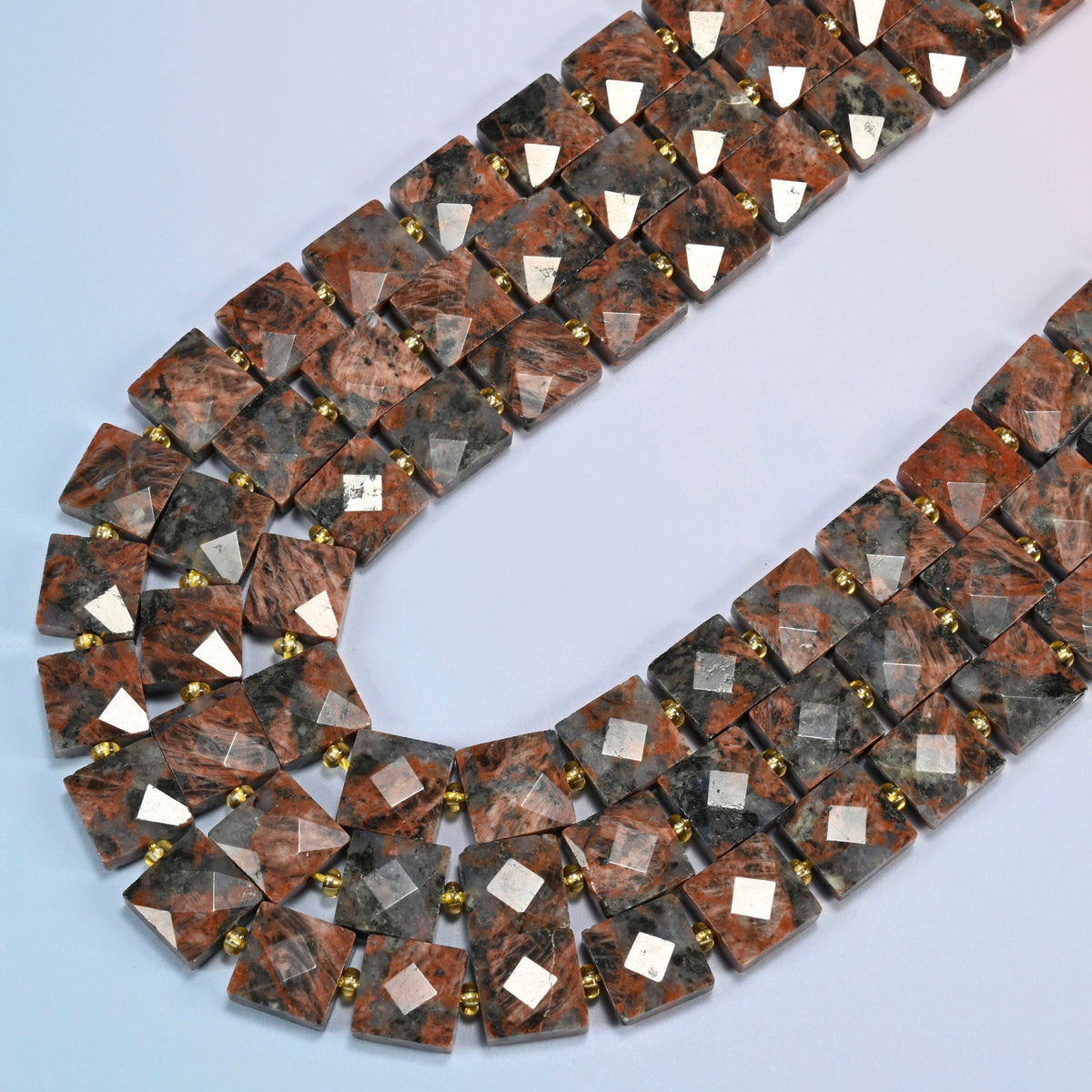 Natural red sesame jasper faceted flat square beads in several strands curved into a wide U, brick red stone with charcoal speckles