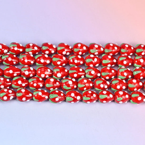 Glossy postbox red strawberry glass beads dotted with white seeds and a green leaf cap