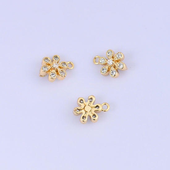 Small gold charms, three flower charms with one turned to show the plain back and its second ring