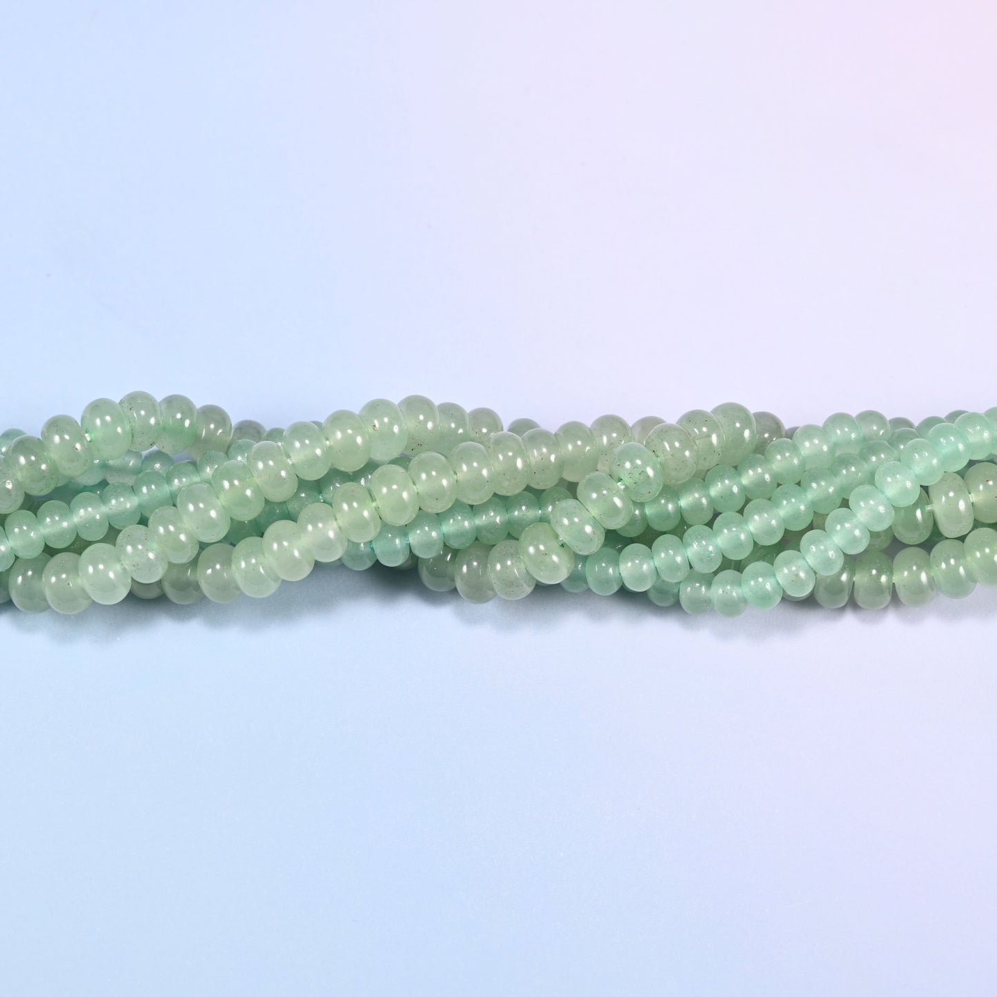 Green Aventurine gemstone rondelle beads twisted together, showing how the discs stack into a ribbed line