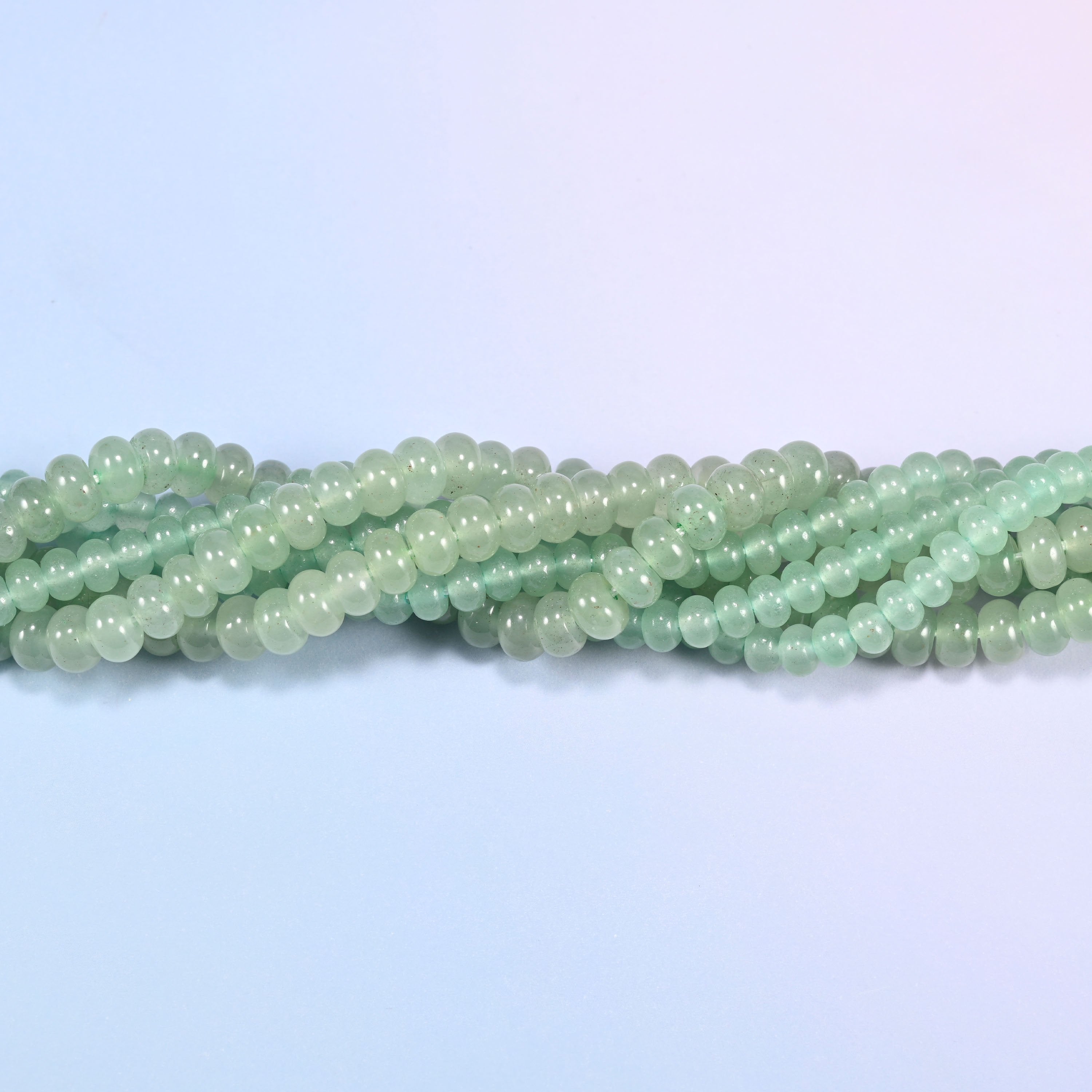 Green Aventurine gemstone rondelle beads twisted together, showing how the discs stack into a ribbed line