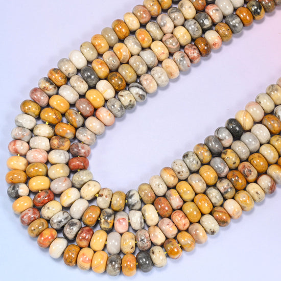 Close-up of Crazy Agate rondelle beads coiled in a circular arrangement on a lavender background.