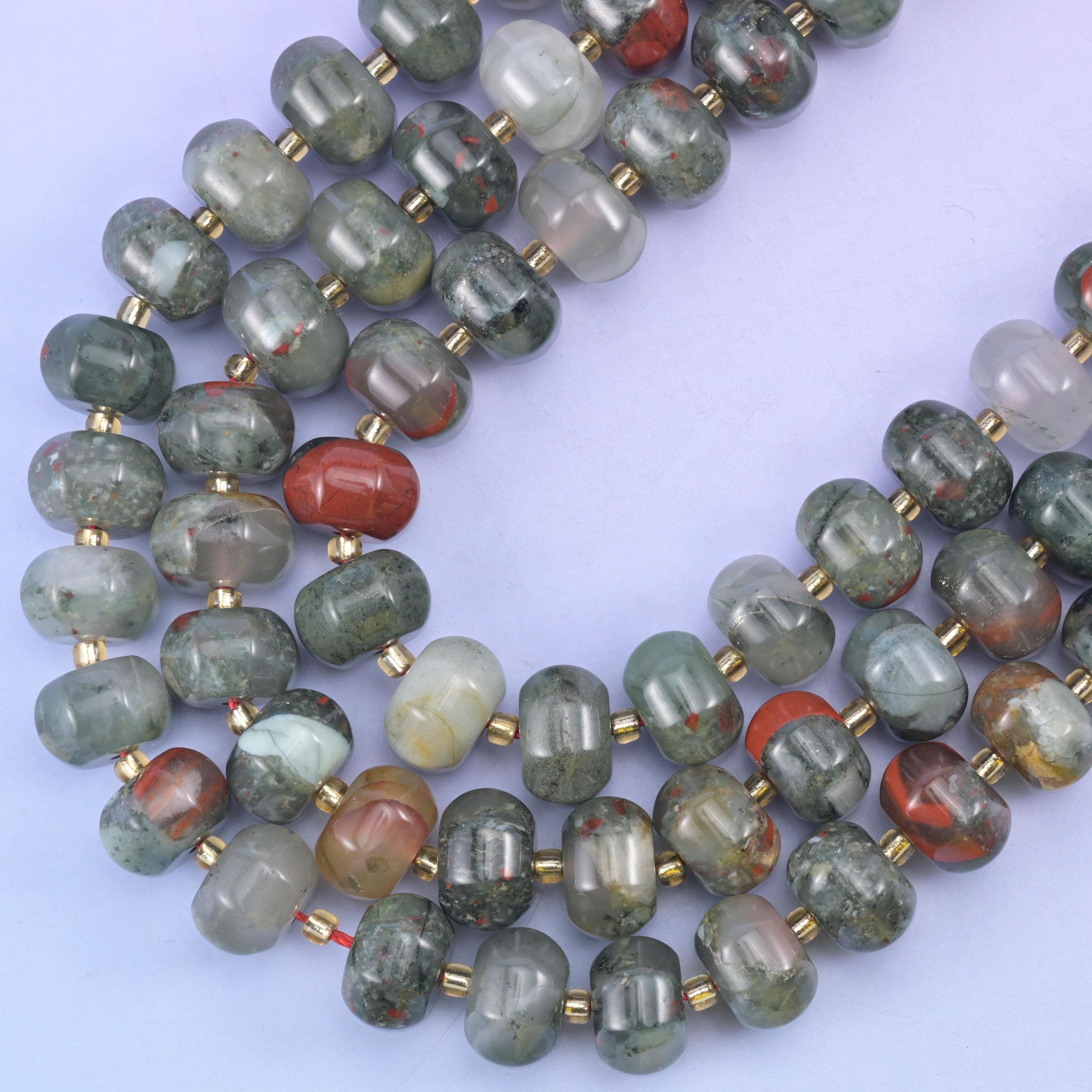 Two strands curving on a soft blue backdrop, the carved melon ribbing clear along every bead
