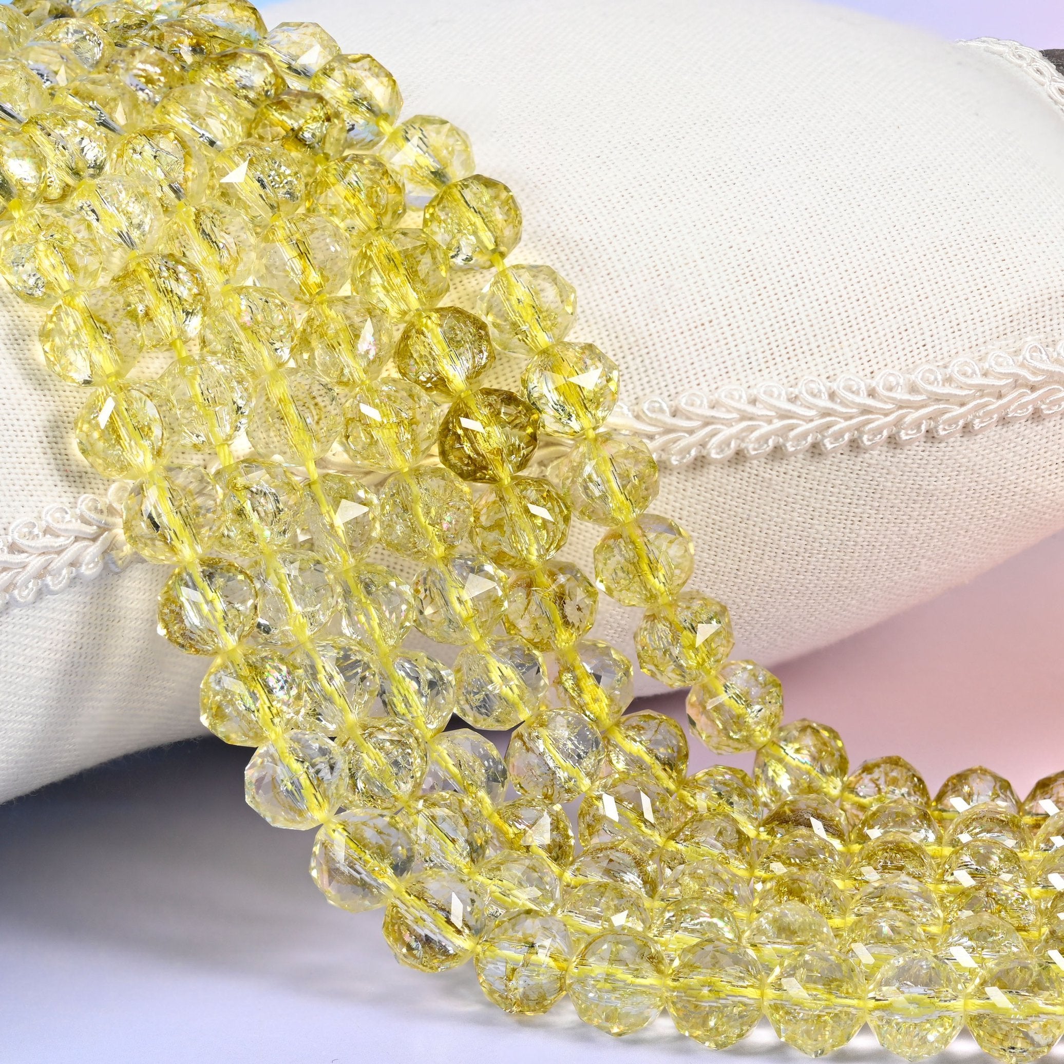 Transparent lemon yellow faceted round glass beads with a clear body that lets the colour pale toward the edges