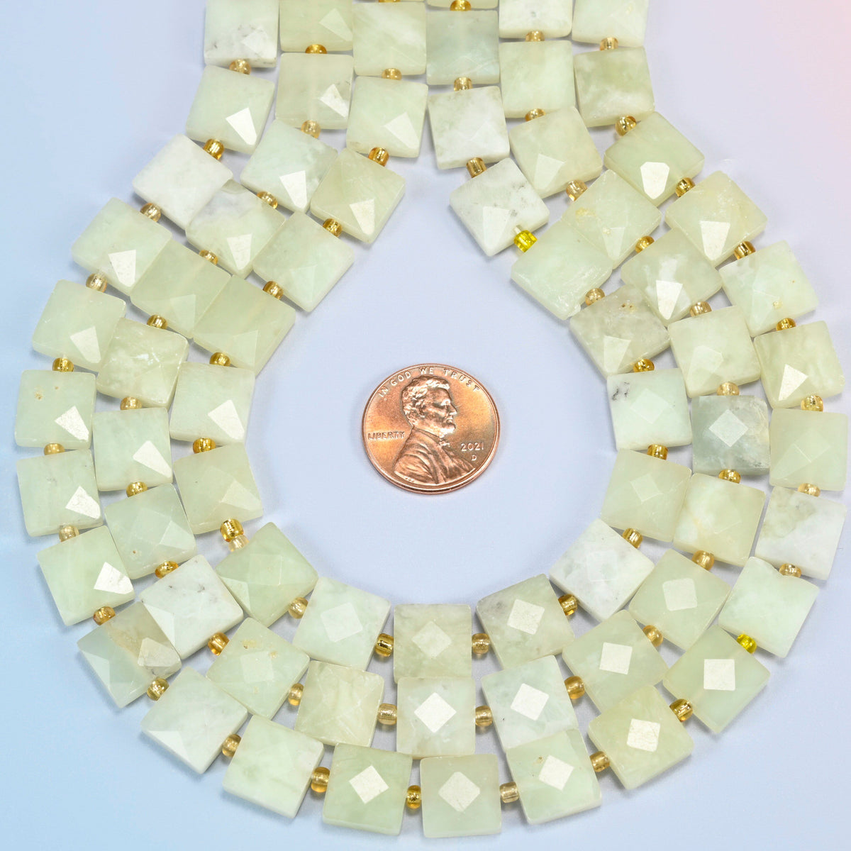 New Jade faceted flat square strands formed into a teardrop loop around a US penny for scale