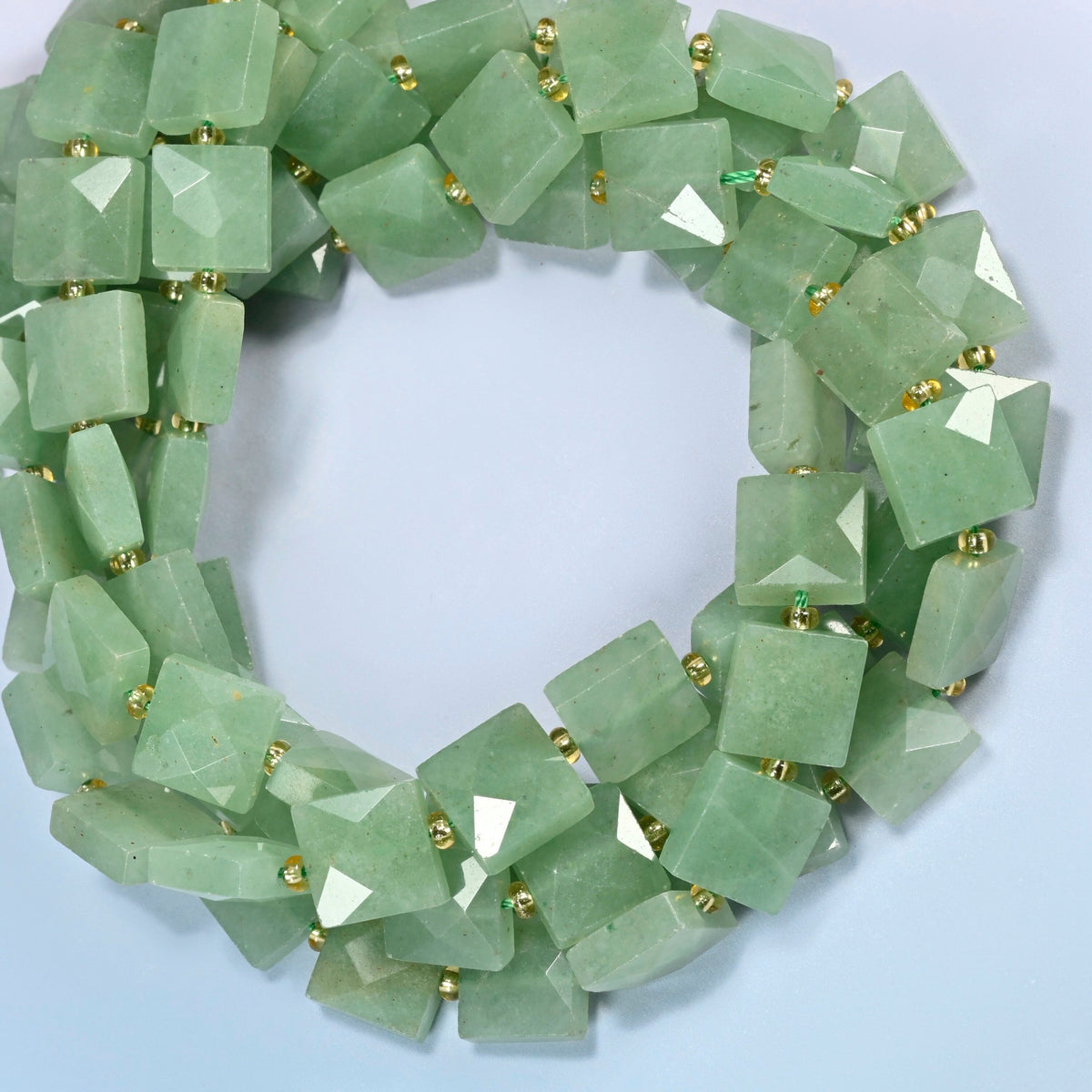 Natural green aventurine faceted flat square beads coiled into overlapping loops, whole strands of soft green stone
