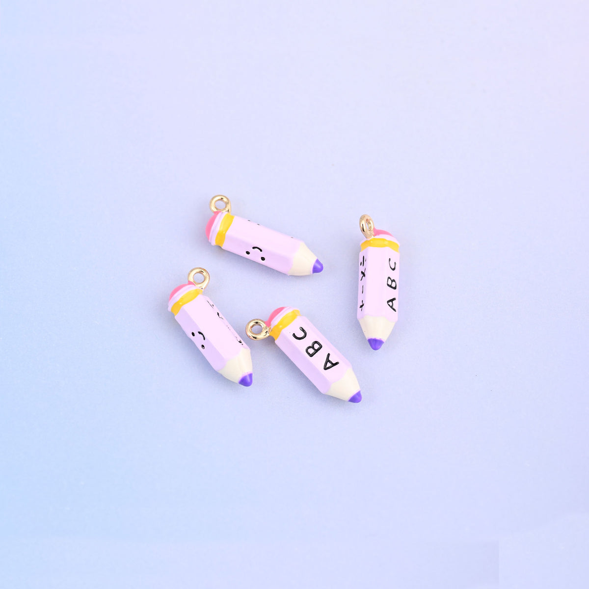 Four light purple pencil charms with yellow bands and purple tips.