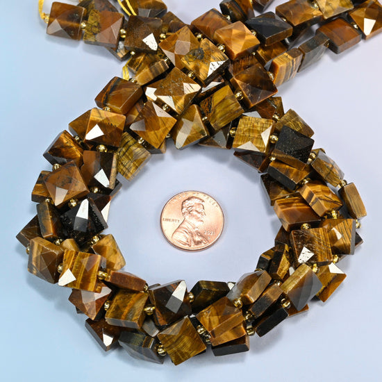 Natural tiger eye faceted flat square beads 10x10mm coiled in a loop around a US penny for scale, close-up of the faceted flat square shape