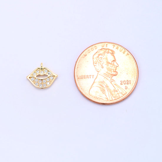 Small gold charms, one lip charm shown beside a US penny for size