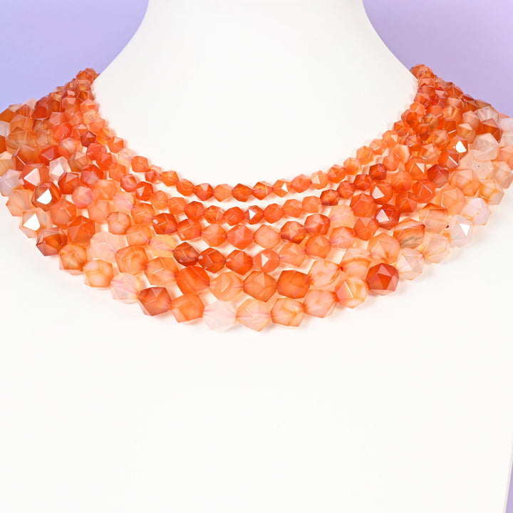 Orange Agate star cut beads looped around a white neck form, several strands sitting together as a collar