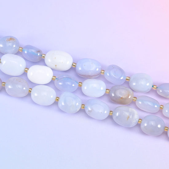 Two strands of 10-17mm chalcedony nuggets running diagonally across a pale lilac backdrop