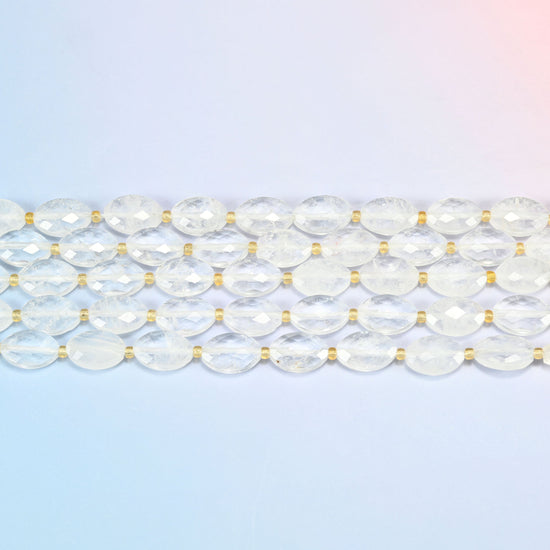 Several strands of clear quartz faceted flat oval beads laid in straight rows with gold seed bead spacers