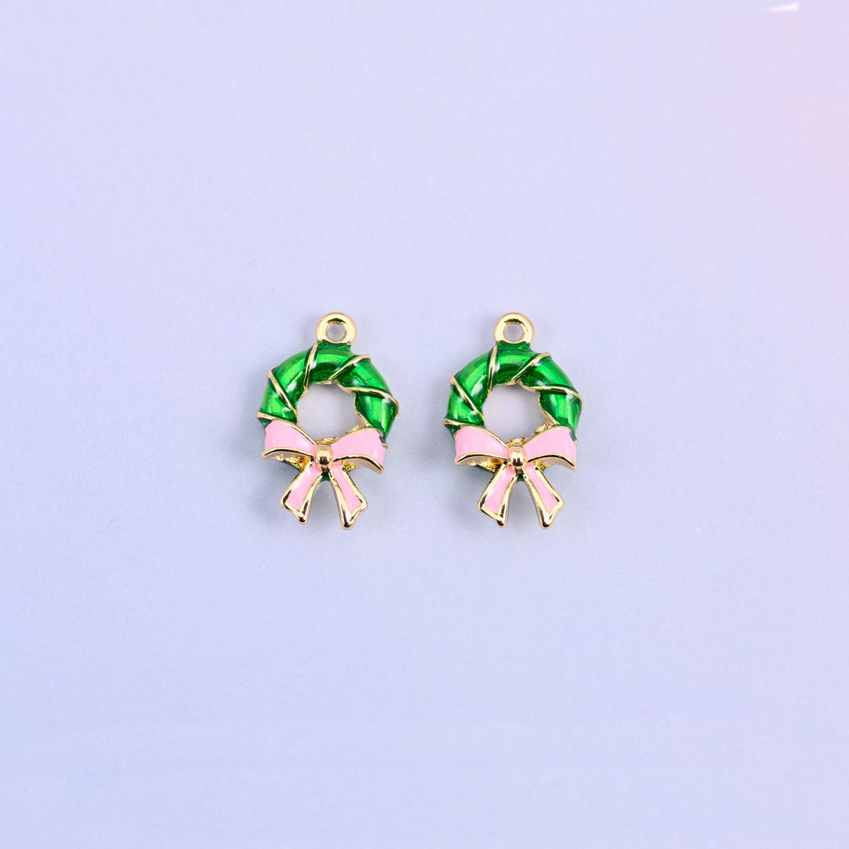 Two green wreath charms side by side, showing the open center of the ring.