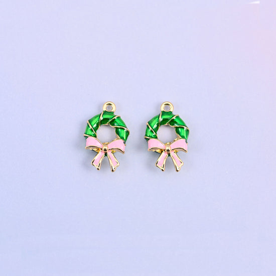 Two green wreath charms side by side, showing the open center of the ring.