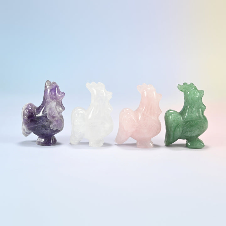 Close view of four gemstone rooster figurines showing the carved comb, puffed chest and curved tail